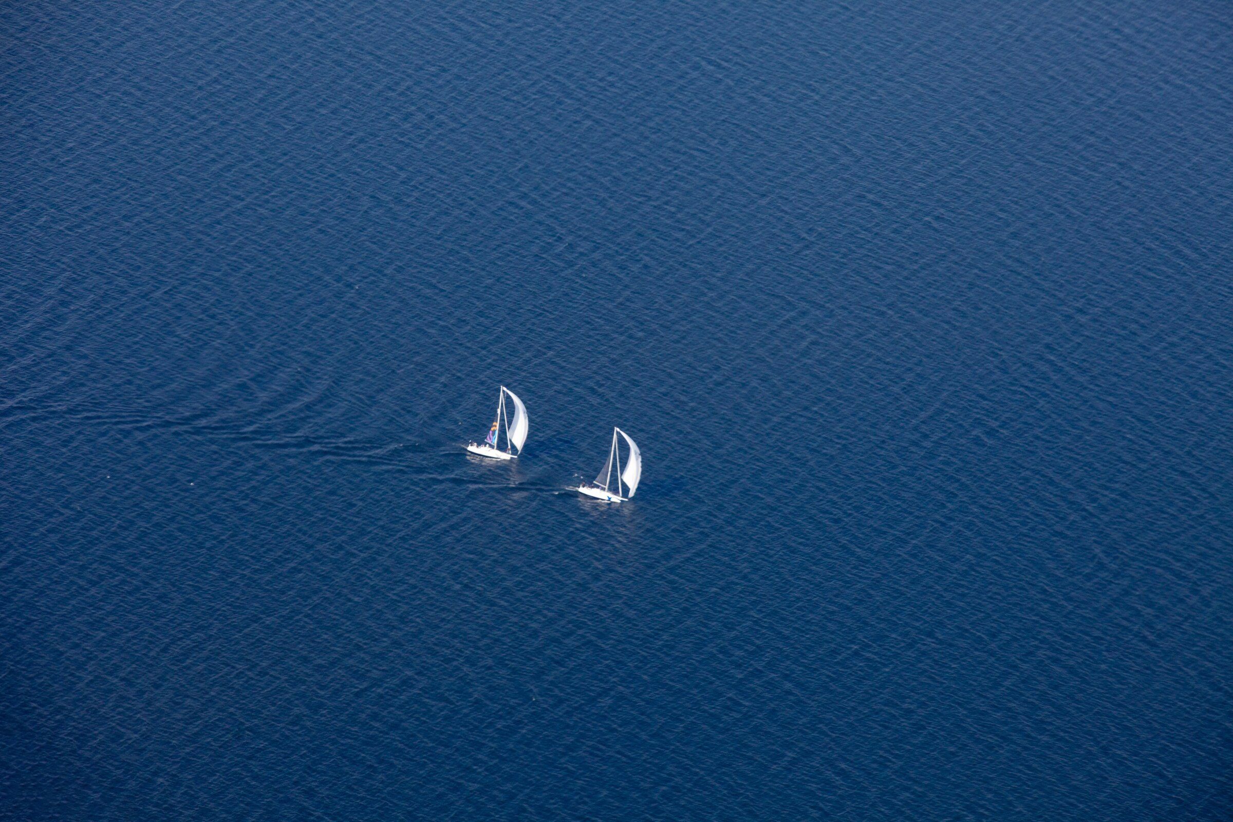 Twee zeilboten op het diepblauwe IJsselmeer, van bovenaf