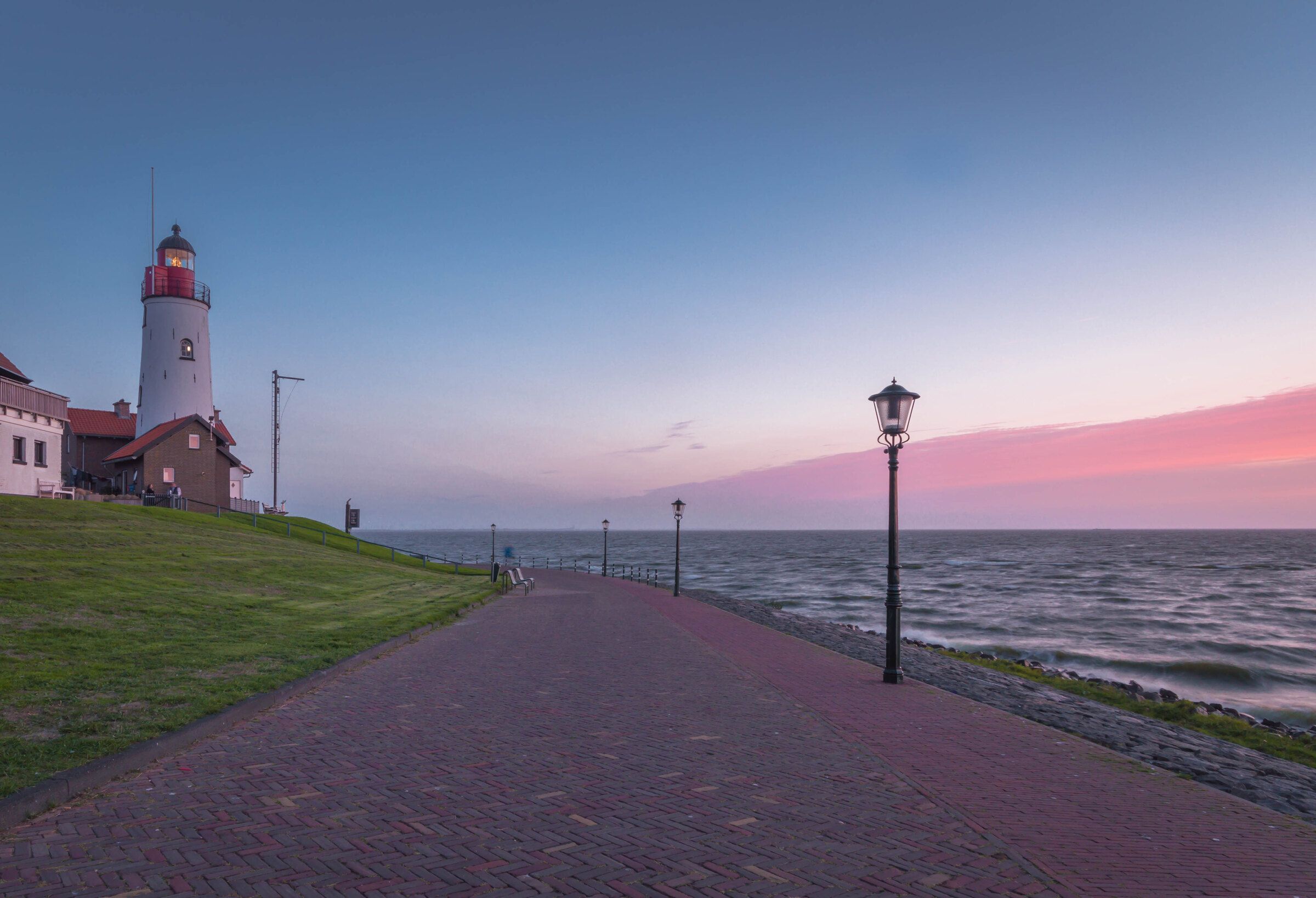 De vuurtoren van Urk bij schemering, met het pad langs het water